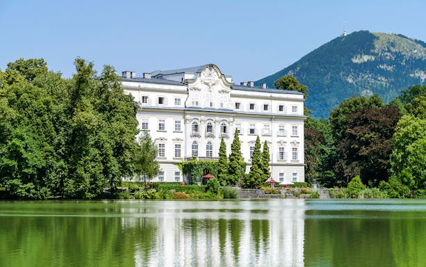Leopoldskron Palace with lake and mountain backdrop, Salzburg, Austria.