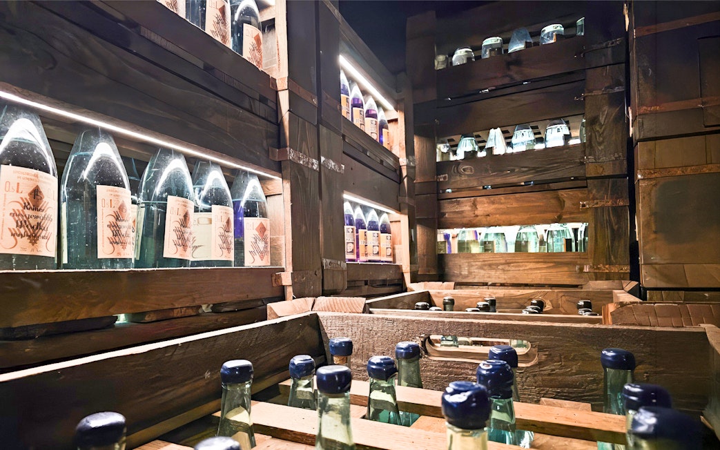 Vodka bottles displayed on wooden shelves at a museum in Krakow.