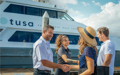 Tourists greeting crew before Cairns half-day snorkeling tour.