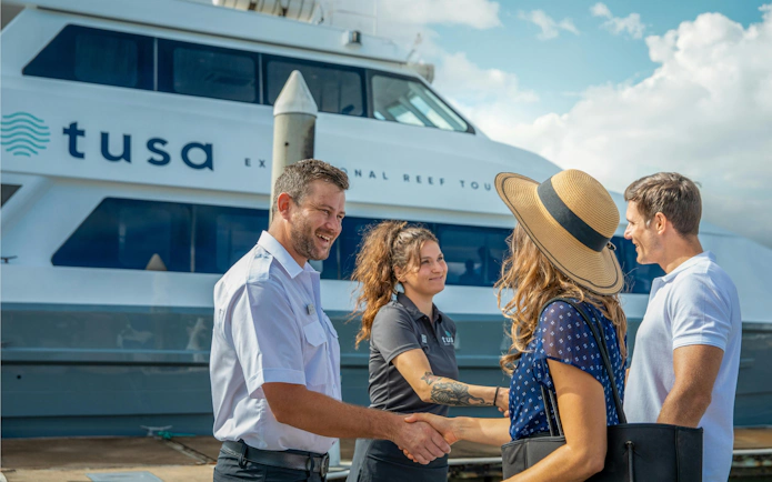 Tourists greeting crew before Cairns half-day snorkeling tour.