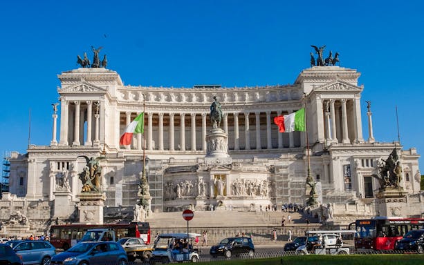 Alt text: "Vittoriano monument with Italian flags on Rome walking tour