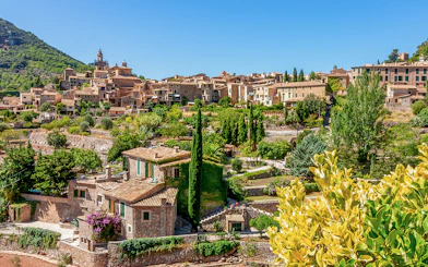 Valldemossa village view with stone houses and lush greenery, Mallorca, Spain.
