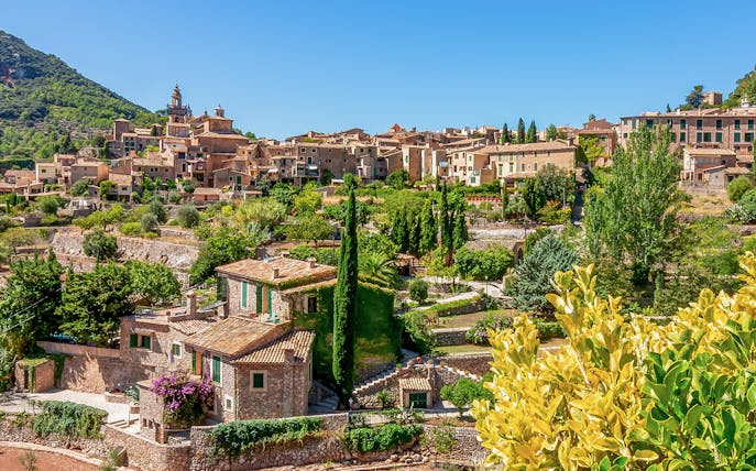 Valldemossa village view with stone houses and lush greenery, Mallorca, Spain.