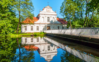 Palace on the Water in Zwierzyniec, Poland, reflected in a tranquil pond.