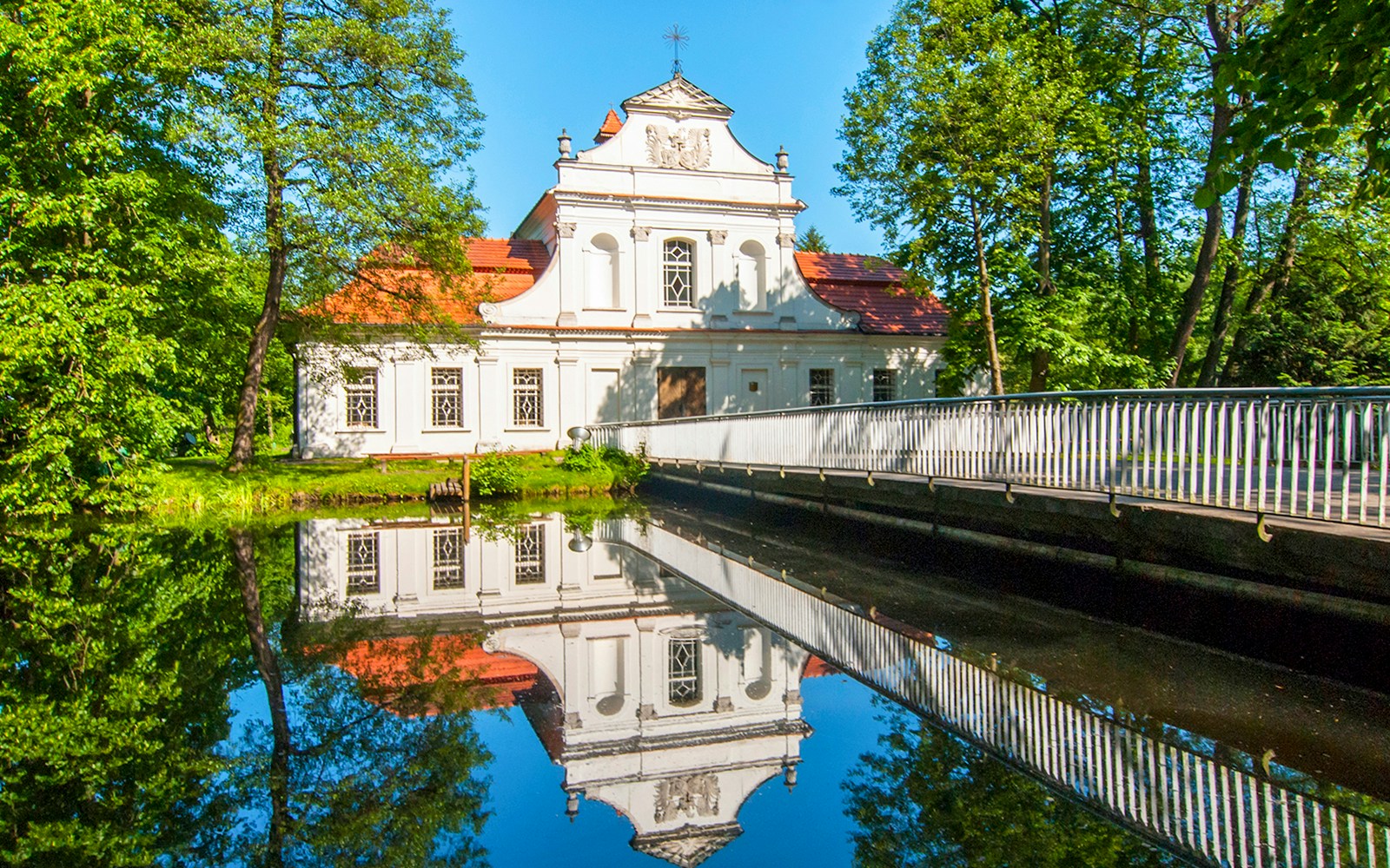 Palace on the Water in Zwierzyniec, Poland, reflected in a tranquil pond.