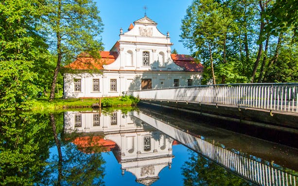 Palace on the Water in Zwierzyniec, Poland, reflected in a tranquil pond.