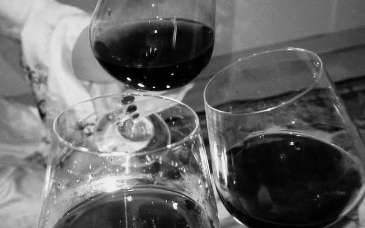 Wine glasses clinking during a blind wine-tasting game in Barcelona with unlimited sangria.
