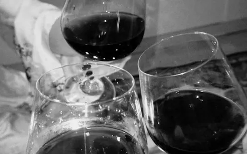 Wine glasses clinking during a blind wine-tasting game in Barcelona with unlimited sangria.