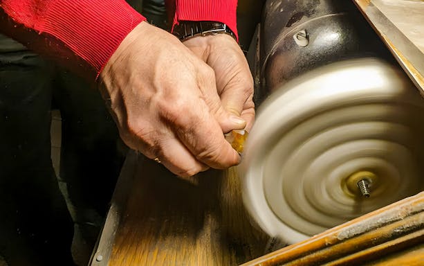 Hands polishing amber at Gdańsk workshop.