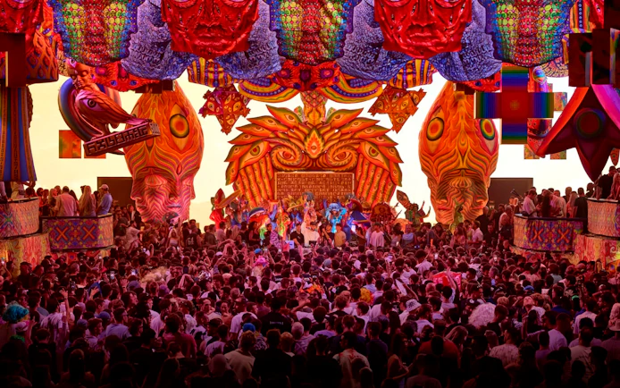Crowd enjoying vibrant elRow performance with colorful decorations in Ibiza.
