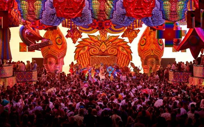 Crowd enjoying vibrant elRow performance with colorful decorations in Ibiza.