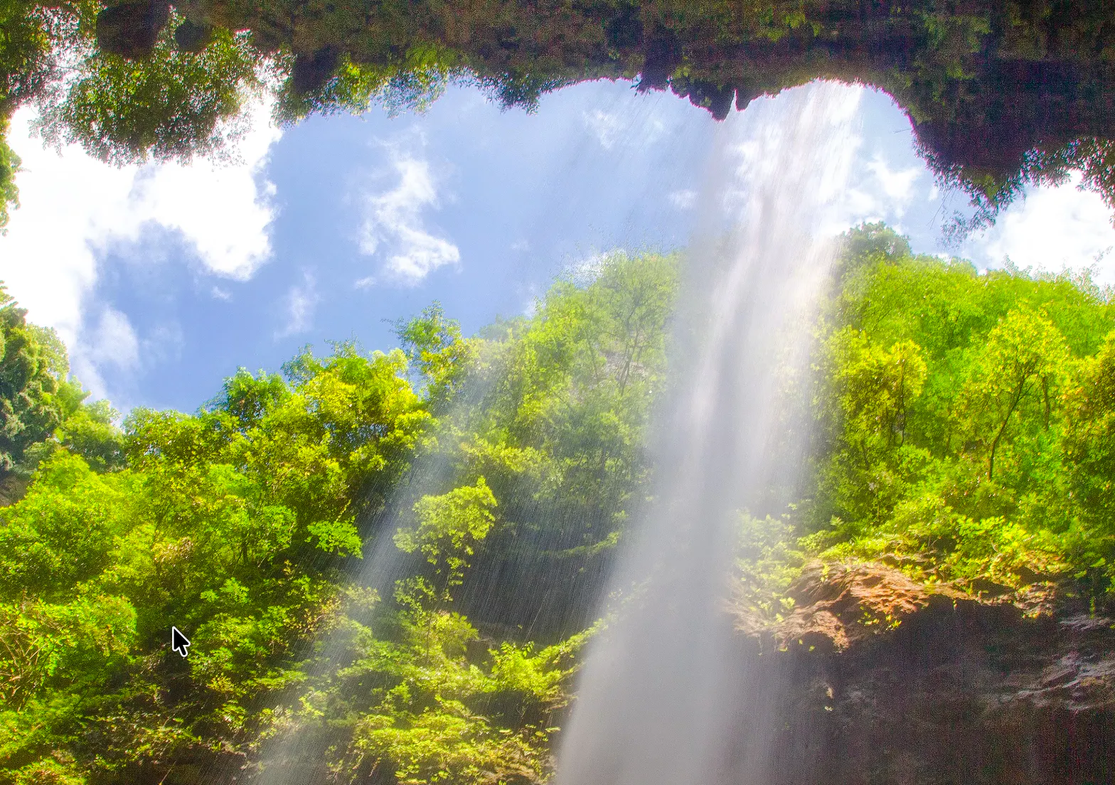 Waterfall cascading through lush greenery at Wulong Three Natural Bridges, Chongqing.
