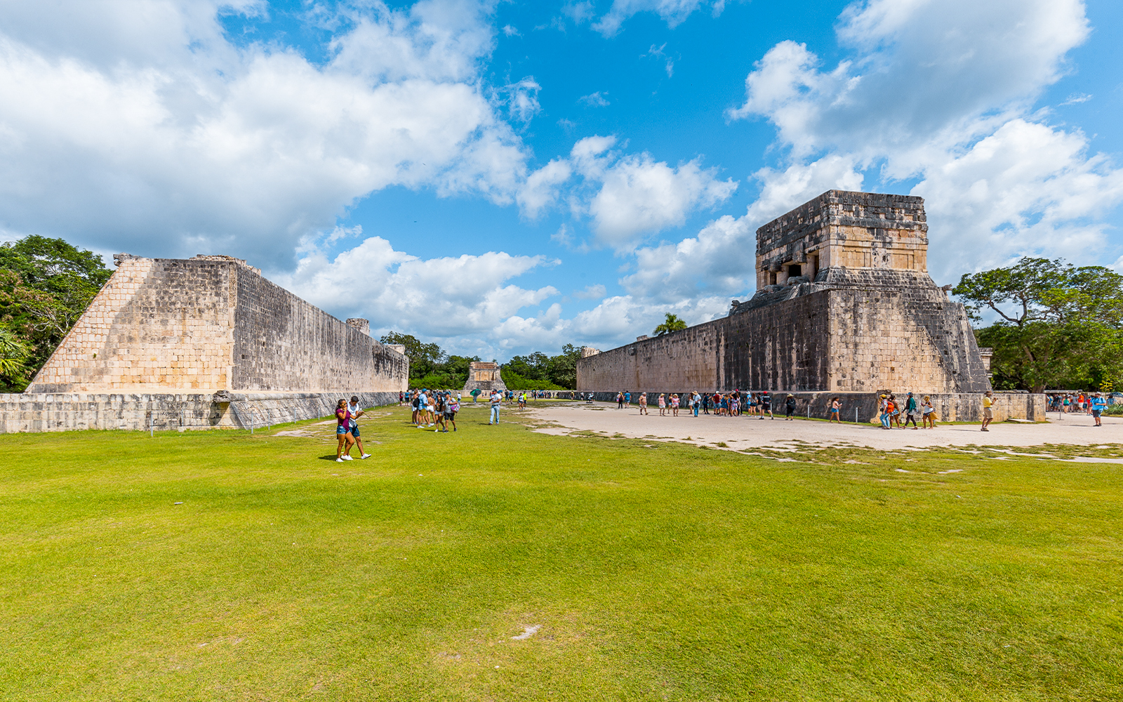 Tourists exploring the ancient ball court at Chichen Itza, Mexico.