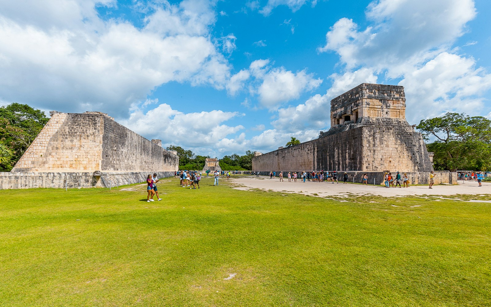 Tourist exploring Chichen Itza Ball Court, ancient Mayan site in Mexico.