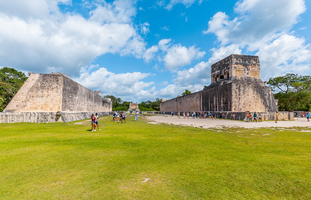 Tourists exploring the ancient ball court at Chichen Itza, Mexico.