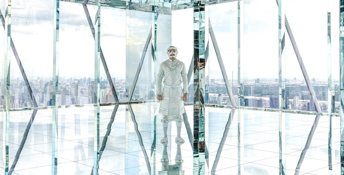 Reflective room with Hanuman figure at Akara Sky, city skyline view.