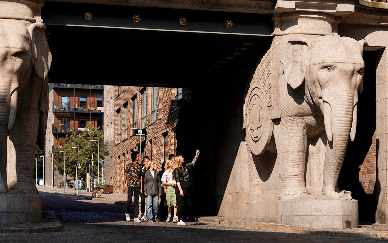 Guests observing elephant sculptures at the entrance of the Carlsberg brewery in Copenhagen.