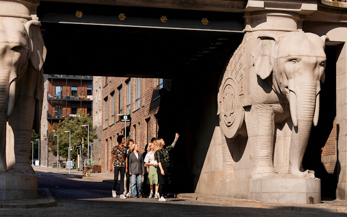 Guests observing elephant sculptures at the entrance of the Carlsberg brewery in Copenhagen.