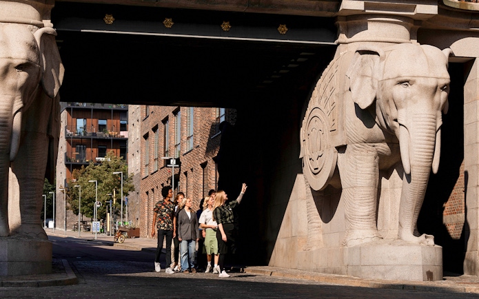 Guests observing elephant sculptures at the entrance of the Carlsberg brewery in Copenhagen.