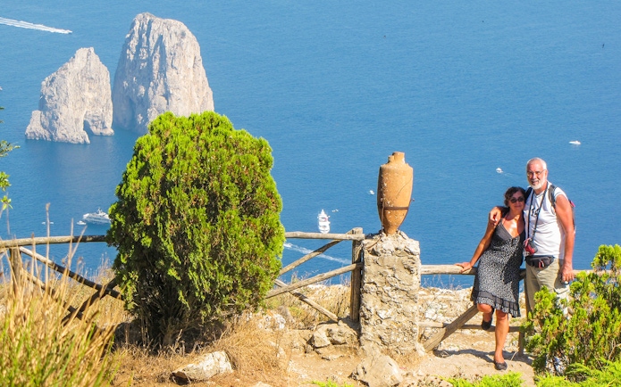 Couple enjoying view of Faraglioni rocks on Capri Island, Italy.
