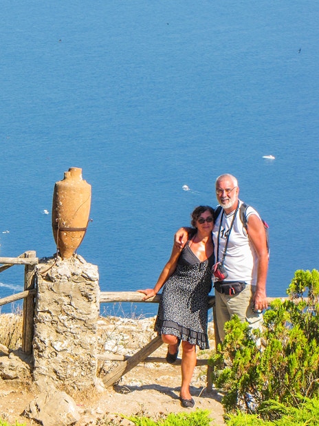 Couple enjoying view of Faraglioni rocks on Capri Island, Italy.