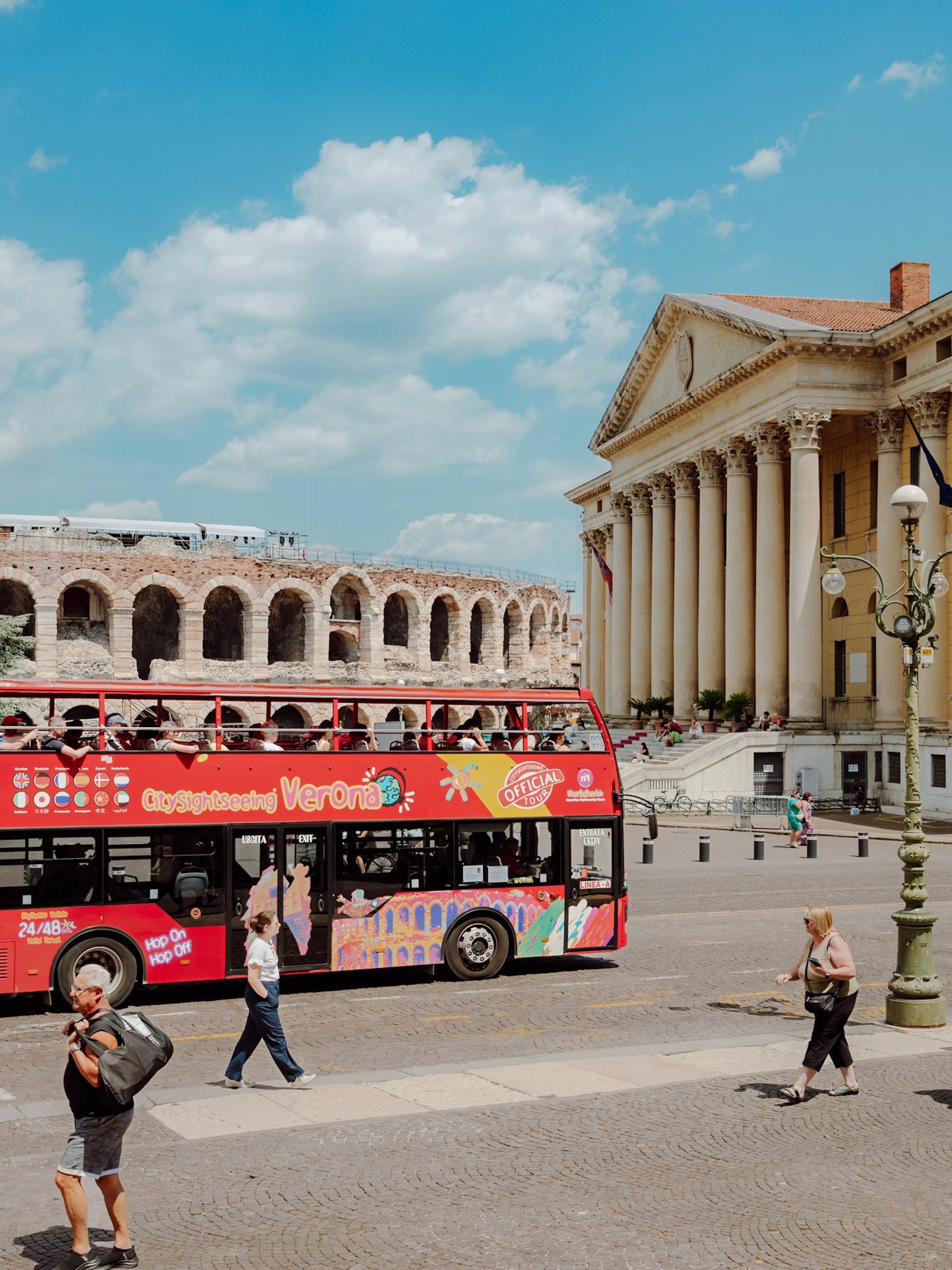 Red City Sightseeing Verona bus near Verona Arena and Palazzo Barbieri.