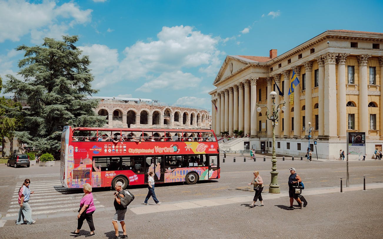 Red City Sightseeing Verona bus near Verona Arena and Palazzo Barbieri.