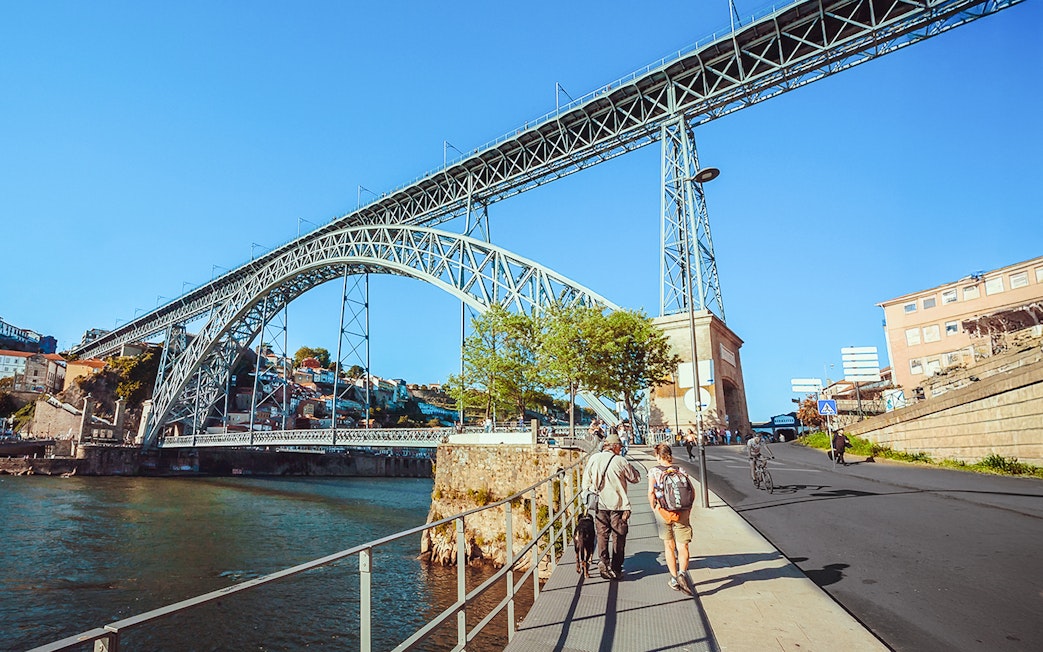 Tourists walking near Ponte D. Luís bridge in Porto.