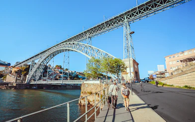Tourists walking near Ponte D. Luís bridge in Porto.