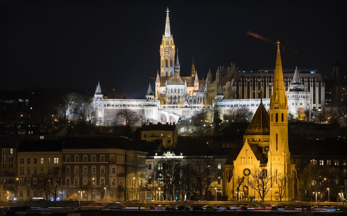The Church of Our Lady illuminated at night from a Danube sightseeing dinner cruise.
