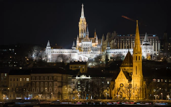 The Church of Our Lady illuminated at night from a Danube sightseeing dinner cruise.