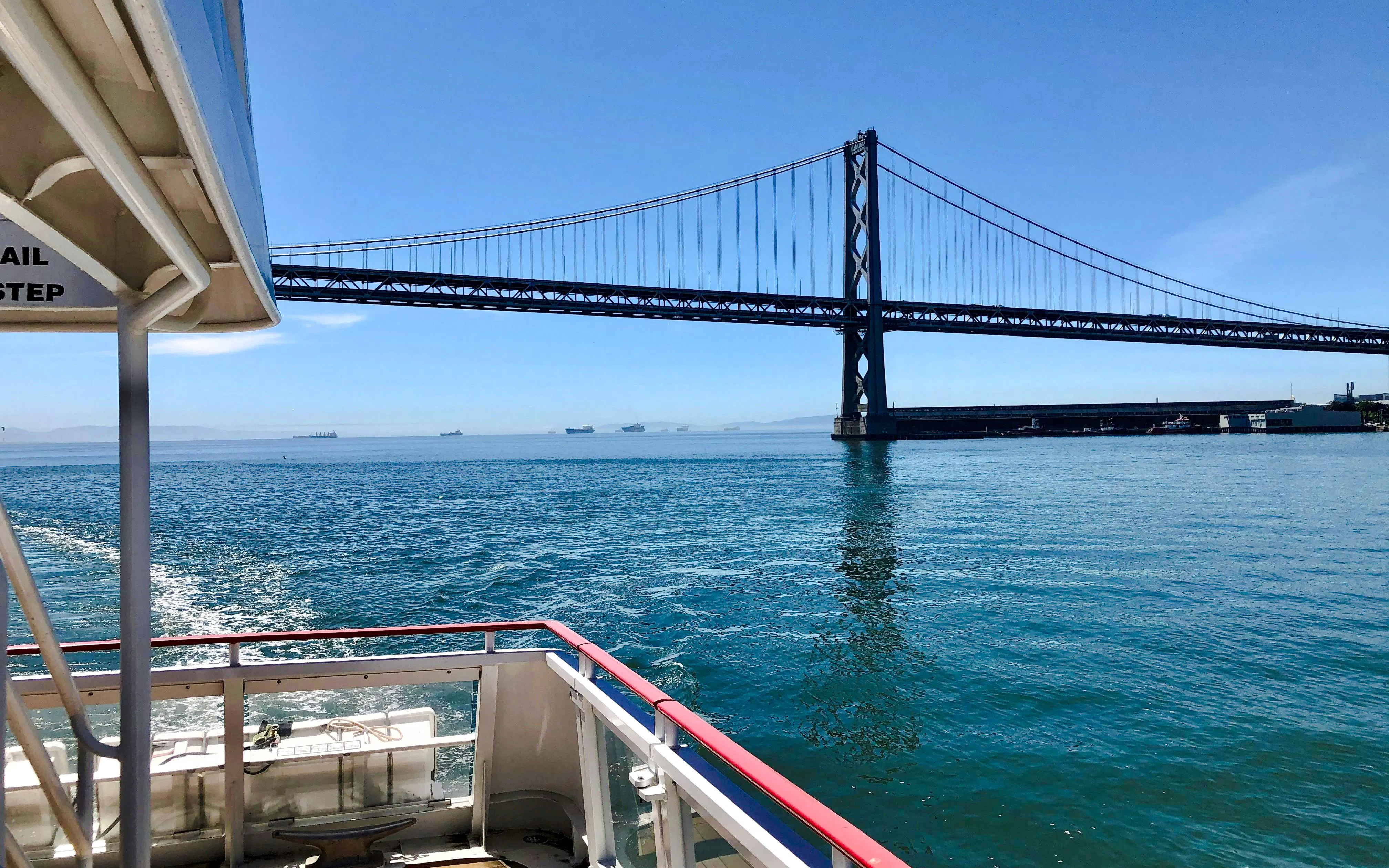 Cruise boat under Bay Bridge on Golden Gate Bay.