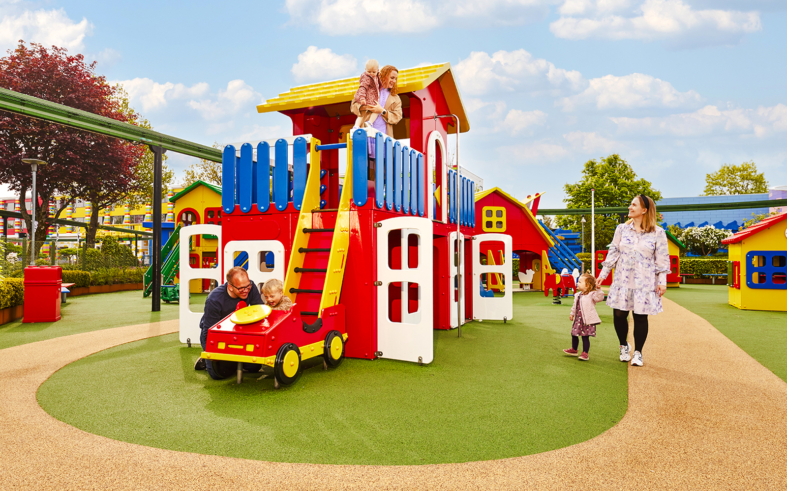 Family enjoying play area at LEGOLAND Billund with colorful structures.