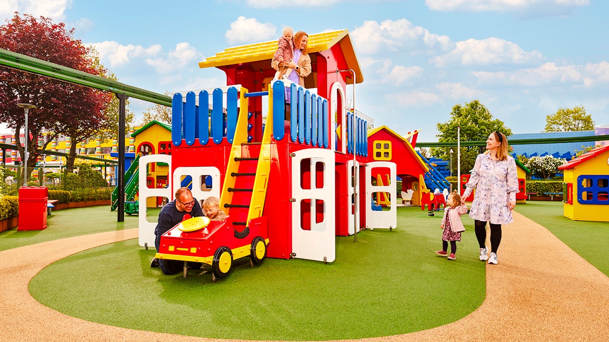 Family enjoying play area at LEGOLAND Billund with colorful structures.