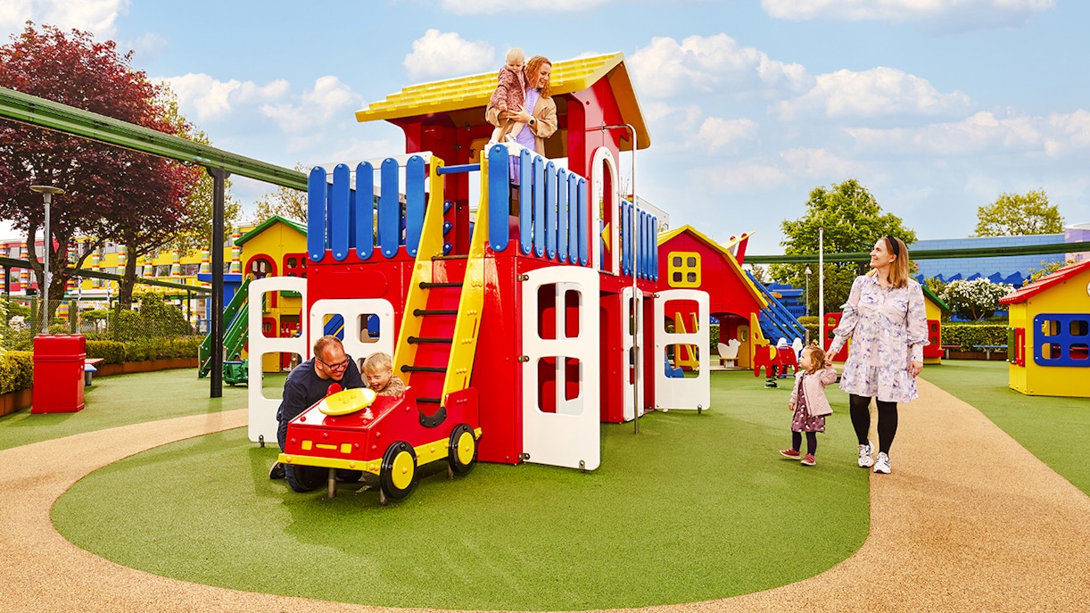 Family enjoying play area at LEGOLAND Billund with colorful structures.