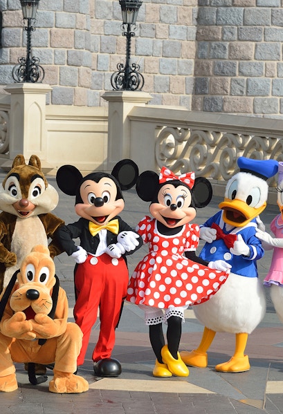 Characters at Disneyland Paris in front of a castle wall.