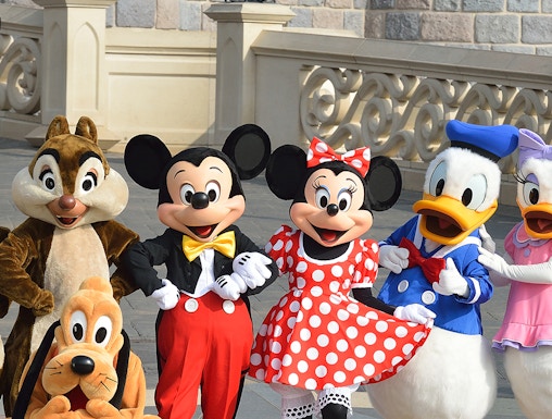 Characters at Disneyland Paris in front of a castle wall.