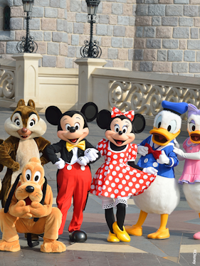 Characters at Disneyland Paris in front of a castle wall.