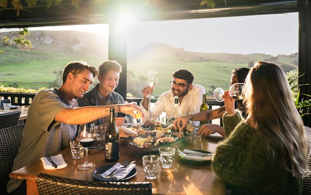Tourists enjoying wine and food at Stonyridge Vineyard, Waiheke Island.