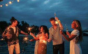 Guests celebrating with sparklers on an evening cruise along Athens Riviera.