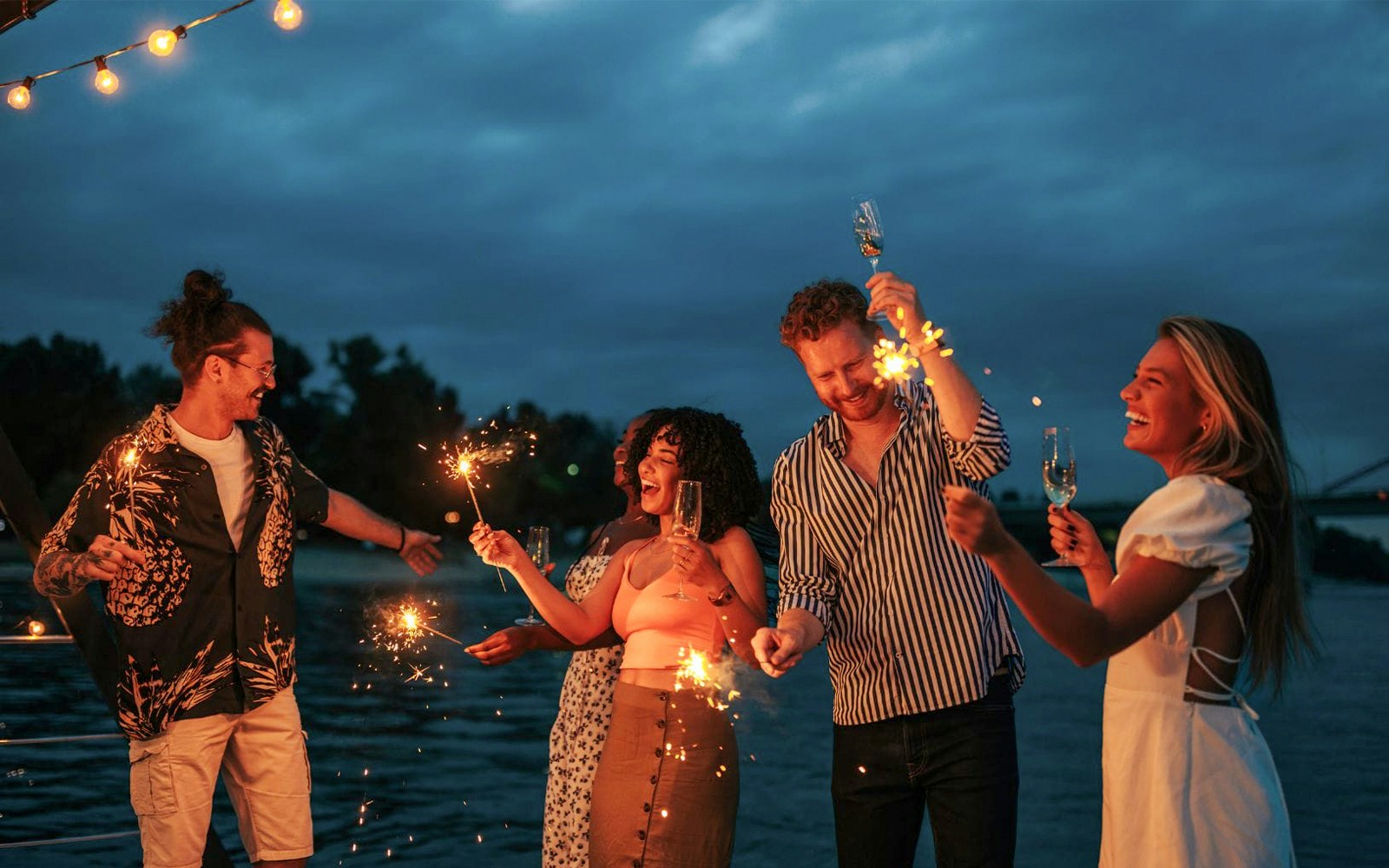Evening cruise on Athens Riviera with guests on deck, city lights illuminating the background.