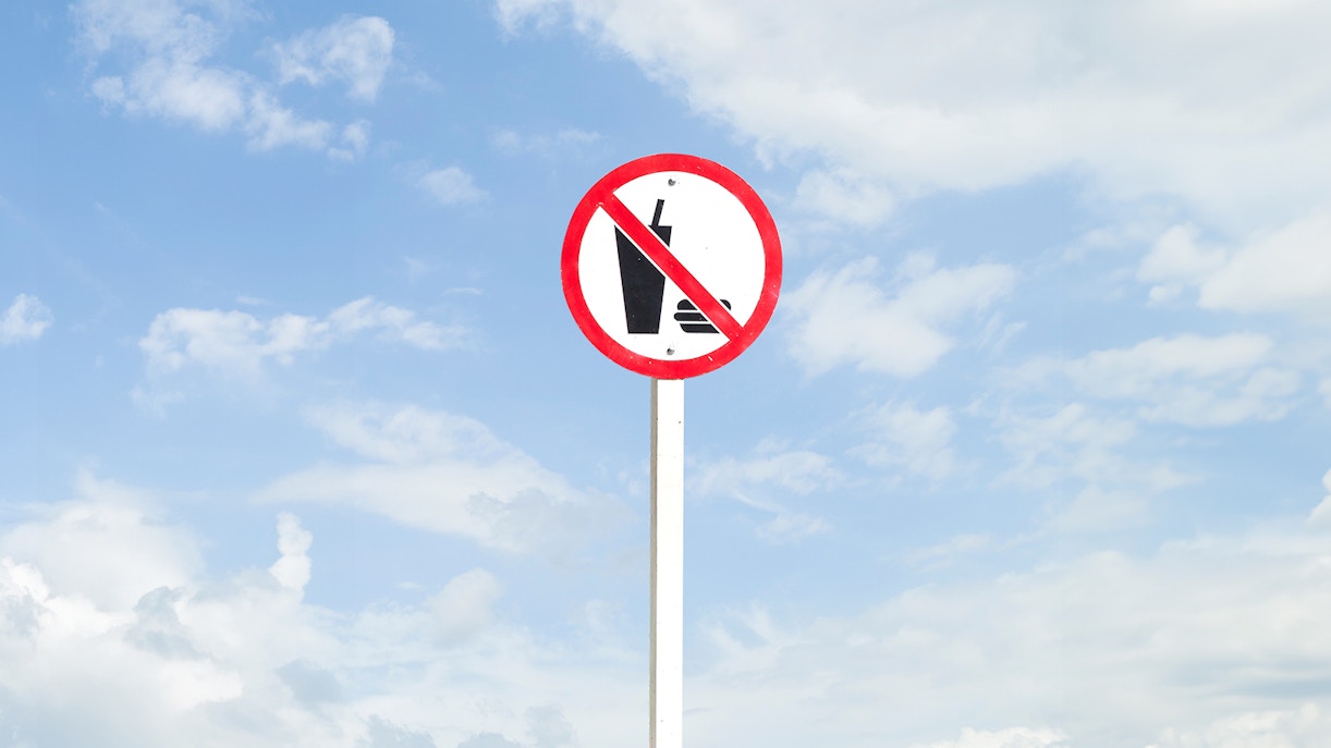 No food or drink sign against a blue sky.