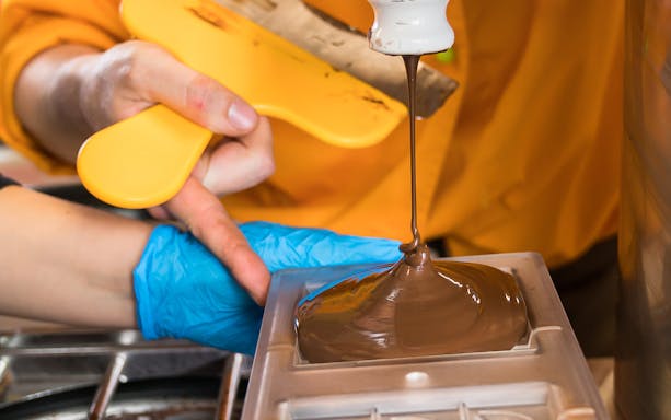 Pouring chocolate into mold during Vienna chocolatier workshop.