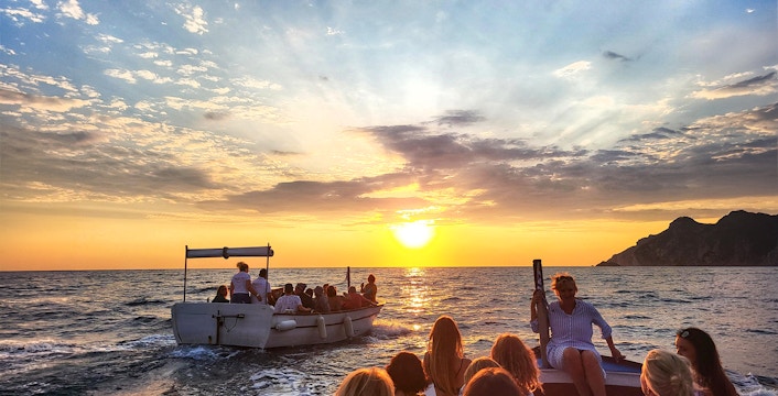Sunset cruise with tourists on a boat near Paleokastritsa, Corfu.