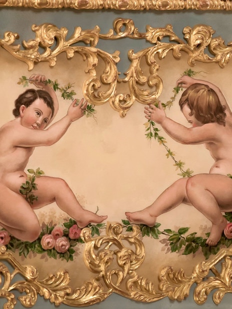 Cherubs with floral garlands in ornate gold frame at Teatro La Fenice, Venice.