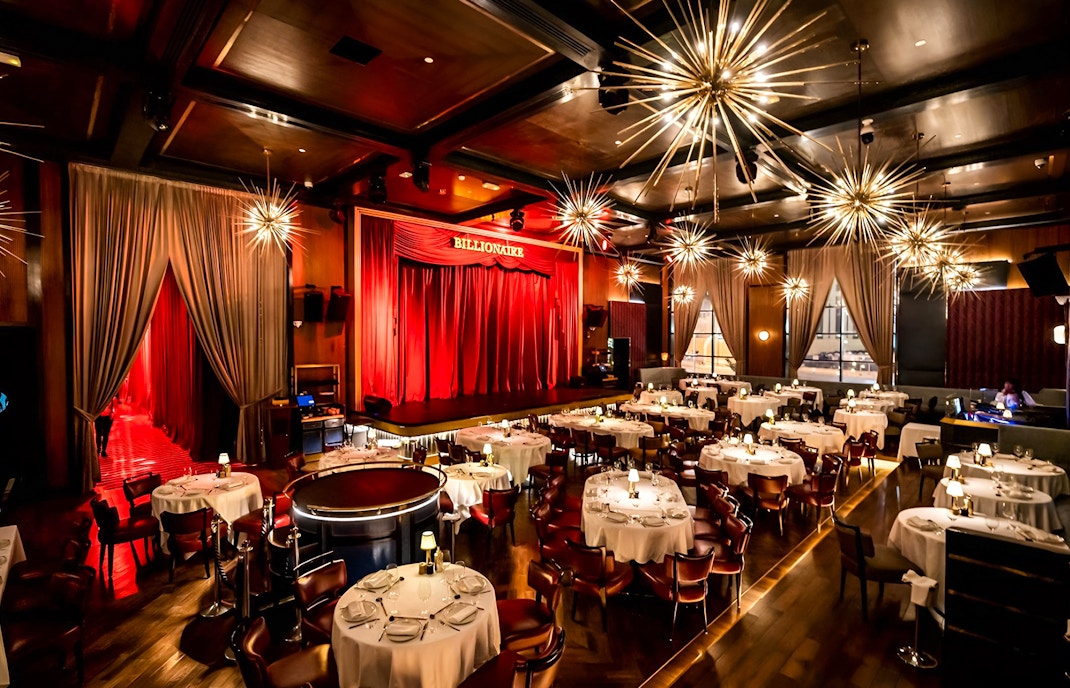 Luxury dining setup with stage at Billionaire Dubai.