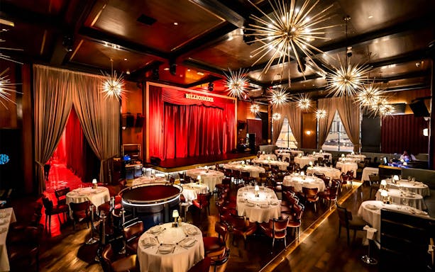 Luxury dining setup with stage at Billionaire Dubai.