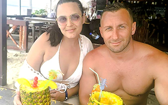 Couple enjoying tropical drinks in pineapples on Islas de San Blas tour, Panama City.