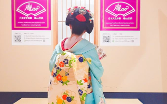Maiko in traditional kimono at Kyoto tea ceremony venue.