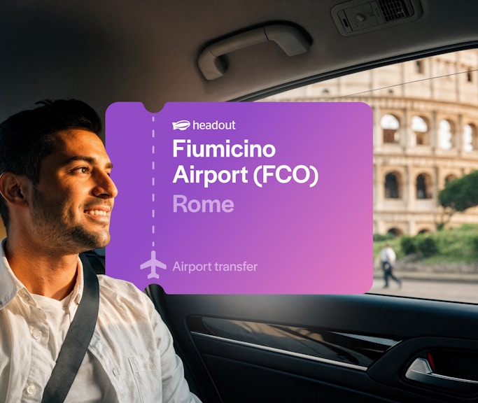 Tourist in cab near Colosseum, Rome with Fiumicino Airport transfer sign.
